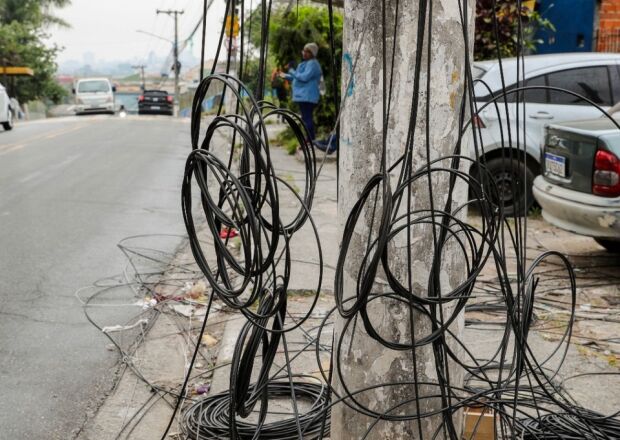 Fios soltos nas calçadas viram tormento e põem pedestres em risco 