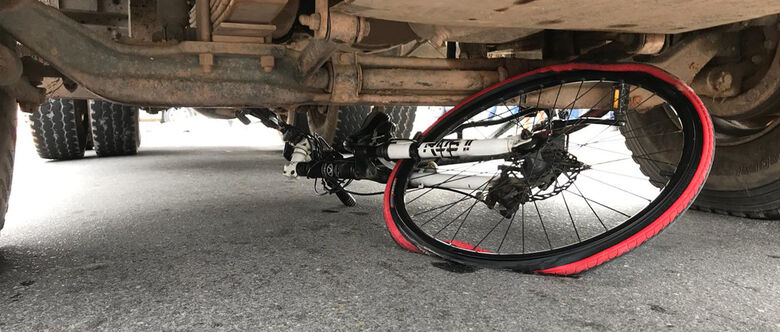 Bicicleta ficou presa embaixo do caminhão